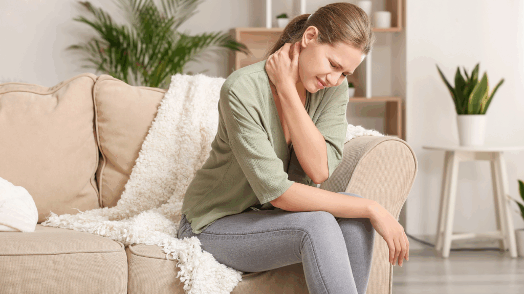 A lady sitting on lounge, holding neck due to Chronic pain